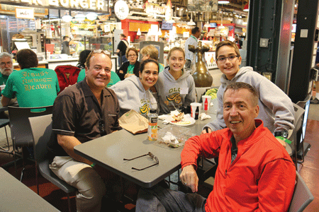 Fr. Ron Richards, right, pastor of St. John Neumann Parish in Canton, stops to grab a bite to eat with parishioners in Philadelphia while waiting for Pope Francis' arrival September 25. Annie Schunior | Archdiocese of Detroit