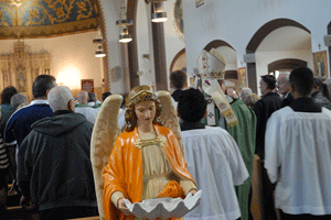 Archbishop Allen H. Vigneron processes past a statue of an angel during the 100th anniversary Mass for Our Lady Queen of Angels Church in southwest Detroit on October 18. Dan Meloy | The Michigan Catholic