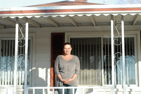 Roseanne Ziebroski stands on the front porch of her new home in Wayne. Ziebroski and her family are beneficiaries of the Society of St. Vincent de Paul's Journey to Housing program, which helps suburban homeless families get back on their feet. Dan Meloy | The Michigan Catholic