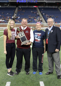 Riverview Gabriel Richard principal Joseph Whalen, second left, accepts the inaugural "Champions of Charity" trophy along with students Bella McLaury (left) and Jessica Baginski (second right), from Larry Griffin, director of resource solicitation for the Society of St. Vincent de Paul. (Courtesy of Society of St. Vincent de Paul)