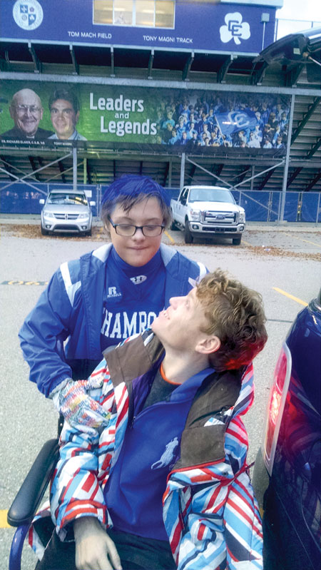 Catholic Central super-fan Johnny Liike, a 13-year old with Down Syndrome who was profiled in The Michigan Catholic's Nov. 13 edition, helps 31-year old Jimmy Gavin, a friend of the Liike family who has Angelman Syndrome and also enjoys attending Catholic Central football games. Courtesy of Suzy Gavin