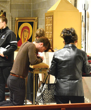 A man prays before the tabernacle after completing his pilgrimage through the Holy Door.
