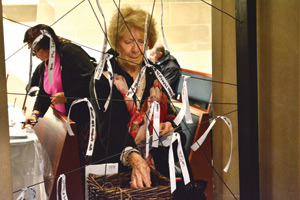 A pilgrim ties her prayer ribbon to the chapel wall inside the cathedral.
