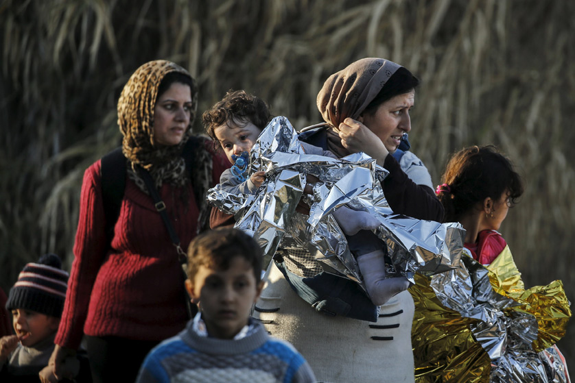 A Syrian refugee carries her child in a thermal blanket as refugees and migrants arrive Nov. 10 on an overcrowded boat on the Greek island of Lesbos. The extensive vetting process that all refugees undergo before arriving in the United States, "screens out any possible threat of terrorism," said the executive director of the U.S. bishops' Migration and Refugee Services. Alkis Konstantinidis | CNS photo