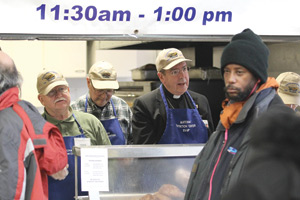 Archbishop Vigneron serves hot meals behind the lunch counter at the Matchan Nutrition Center in Pontiac.