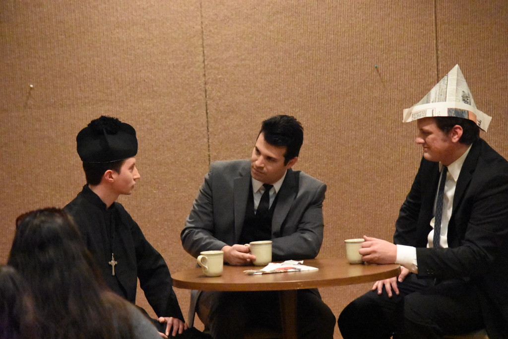 Rob Wallet (Padre Pietro), John Cristiano (Pier Giorgio Frassati) and Seth Borders (Marco Beltramo) sit around a table during a student meeting in a scene in the play "The Life of Blessed Pier Giorgio Frassati" performed by the Frassati Society of Detroit’s “Shady Characters.” (Dan Meloy | The Michigan Catholic)