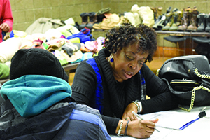 Carolyn Rayford of Alternatives for Girls completes a homeless survey form with a man at the Coleman A. Young Community Center.
