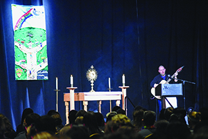 Michael Chamberland plays his guitar during adoration at the CYO Rainbow Conference.