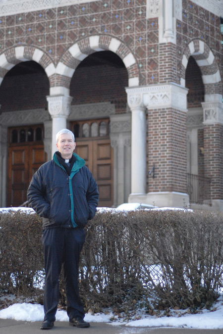 Msgr. Daniel Trapp, pastor of St. Augustine and St. Monica Parish on Detroit's East side, stands in front of the Church, which organizes a neighborhood association once a month to help fight crime and blight and build a sense of community. Mike Stechschulte | The Michigan Catholic