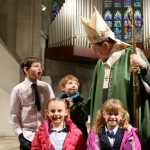 Archbishop Allen H. Vigneron poses at the Feb. 4 Catholic Schools Week Mass with students from Holy Redeemer School in Detroit, which won first place in the Catholic Identity Awards. Courtesy Fr. Dennis Walsh, SOLT