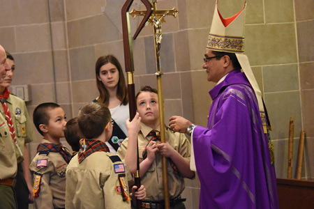 A young scout holds Bishop Cepeda's crozier while another holds the processional cross during the annual recognition Mass for scouting at the Cathedral of the Most Blessed Sacrament. Dan Meloy | The Michigan Catholic