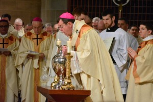 Archbishop Allen H. Vigneron breathes into the sacred Chrism oil during the annual Chrism Mass at the Cathedral of the Most Blessed Sacrament on March 24, Holy Thursday morning. (Photos by Mike Stechschulte, The Michigan Catholic)