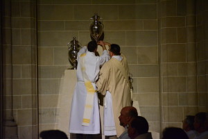 Deacons place the newly blessed oil of the sick, oil of catechumens and sacred Chrism in their place at the cathedral.