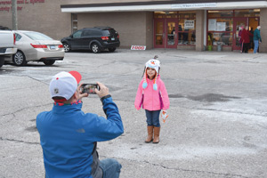 Mitch Koleczko takes a picture of his daughter, Sofia, in front of St. Germaine School fish fry Feb. 26.
