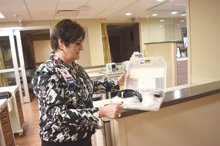 Karen Bostick, RN, opens up a listening device for hearing-impaired patients, one of the many innovations at the hospital's senior emergency center.
