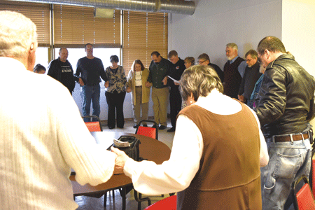St. Robert Bellarmine parishioners pray in the parish hall before the start of a parish dialogue gathering April 10.