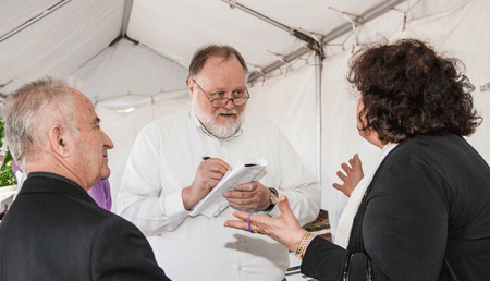 Longtime Michigan Catholic reporter Robert Delaney interviews the parents of then-newly ordained Fr. Marko Djonovic in 2013. Delaney, who died April 11  at the age of 65, was an institution at The Michigan Catholic for 22 years. Larry Peplin | The Michigan Catholic file photo