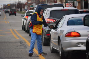 Gary Sorice collects a donation from a driver on the corner of Eureka and Fort streets in Wyandotte on March 19.