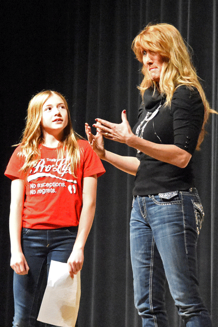Rebecca Kiessling, accompanied by her daughter, Karina, speaks to students during the 10th annual "Building Bridges to a Culture of Life" pro-life youth conference April 9 at Mercy High School in Farmington Hills. Dan Meloy | The Michigan Catholic