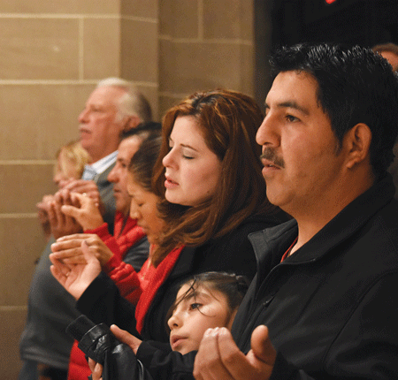 Massgoers close their eyes and sing during the Pentecost vigil Mass on May 14 at the Cathedral of the Most Blessed Sacrament