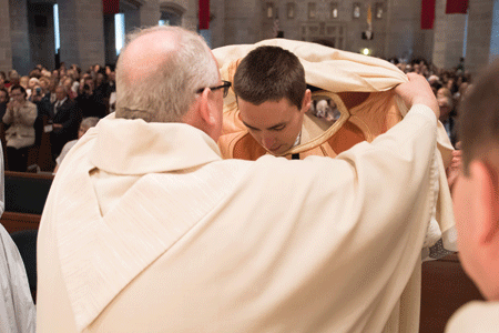 Fr. Kevin Roelant receives his vestments after being ordained May 14 by Archbishop Vigneron at the Cathedral of the Most Blessed Sacrament.