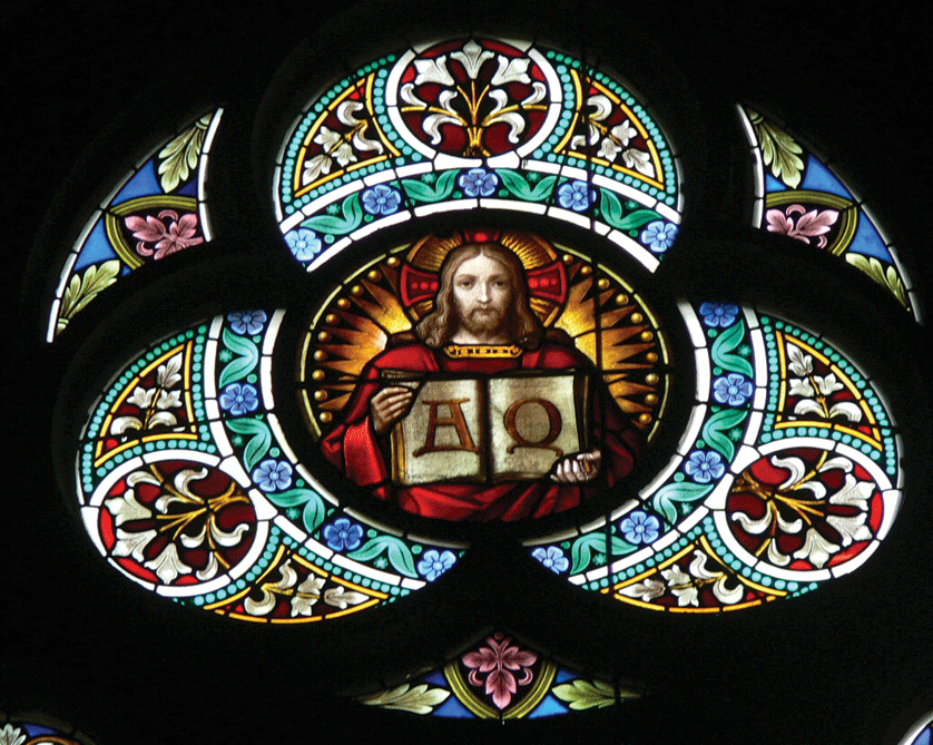 Jesus holds open the Scriptures containing the Greek letters for Alpha and Omega in this stained glass in Austria. The letters "Alpha" and "Omega" are the English equivalent of "A" and "Z" and represent God's preeminence over all things. CNS photo