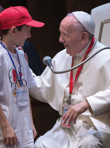 Pope Francis greets a boy during a meeting with hundreds of children at the Vatican May 28. Though the first Vatican Council officially defined the dogma of papal infallibility, the teaching has been present in the Church from the beginning. Maria Grazia Picciarella | CNS Photo