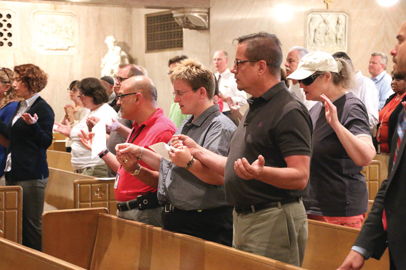 People pray the "Our Father during a special interfaith prayer service June 13 at St. Aloysius Church in downtown Detroit for the victims of Orlando Massacre.  The Michigan Catholic