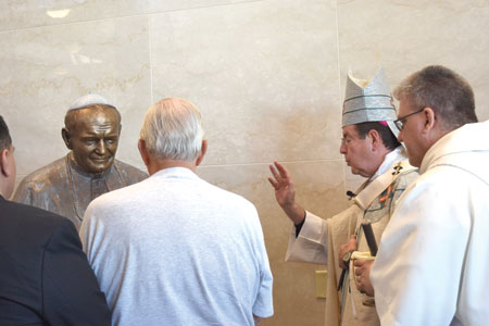 Archbishop Vigneron pauses to bless a life-size statue of St. John Paul II inside the new mausoleum. 