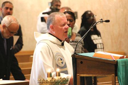 Msgr. Timothy Hogan leads a prayer service for Orlando shooting victims June 13 at St. Aloysius Church in downtown Detroit. The Michigan Catholic