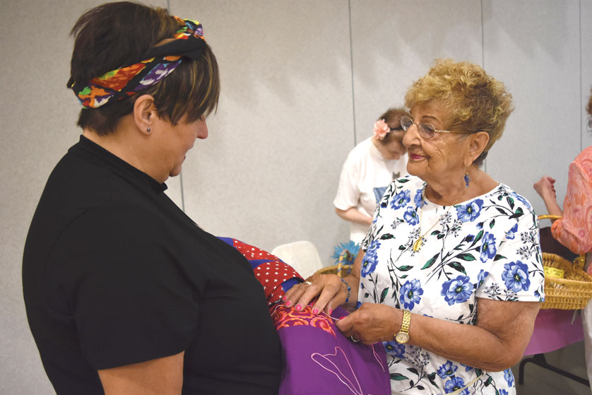 Shelli Jump, St. William Parish Christian service director, assists senior volunteer Vita Harter with the parish's prayer quilt ministry. The prayer quilt ministry, along with many others around the parish, is one of the many ways seniors volunteer their time to enrich parish's mission. Photos by Dan Meloy | The Michigan Catholic