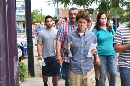 A young man prays as he walks in a Eucharistic procession through Royal Oak on July 16. For some young adults, where to attend Mass depends on where they happen to be each week. Mike Stechschulte | The Michigan Catholic
