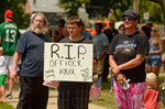 Mourners alongside the road look on as a procession of hundreds of police vehicles exit St. Robert Bellarmine and make their way to Holy Sepulchre Cemetery.