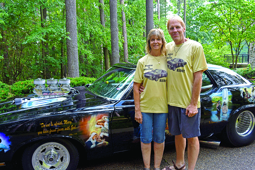 Dennis and Christine Hatmaker, parishioners of Holy Spirit Parish in Highland and St. John the Evangelist in Fenton, show off their 1972 Oldsmobile Cutlass Pro Streeter adorned with images from the Gospel and salvation history outside their home in Highland. The Hatmakers will drive the hot rod in the Woodward Dream Cruise this weekend, where they plan to hand out rosaries and talk about their two great loves: cars and Christ.