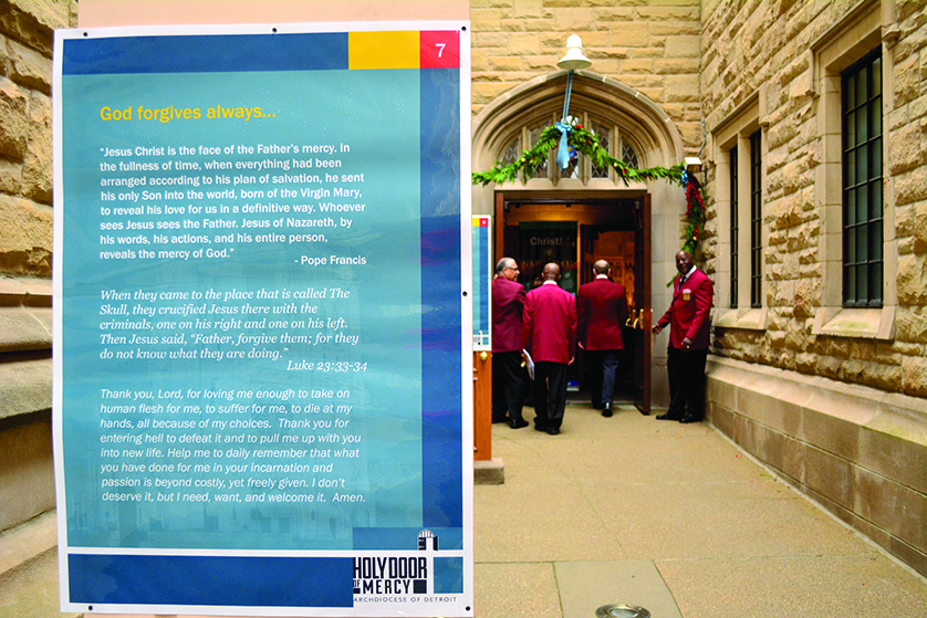 An usher holds open the Holy Door of Mercy at the Cathedral of the Most Blessed Sacrament in Detroit. During the Year of Mercy, Catholics who pass through the holy door may receive a plenary indulgence provided they meet other conditions including the confession of sins, reception of the Eucharist and the offering of specific prayers.