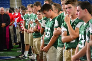 Student-athletes pray the rosary at Ford Field. 