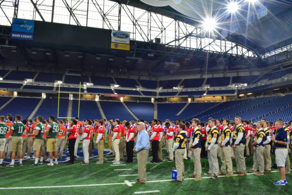Coaches, players and administrators line up on the turf at Ford Field during a rosary rally to kick off the 90th season for the Catholic High School League on Aug. 19. (Photos by Mike Stechschulte | The Michigan Catholic)