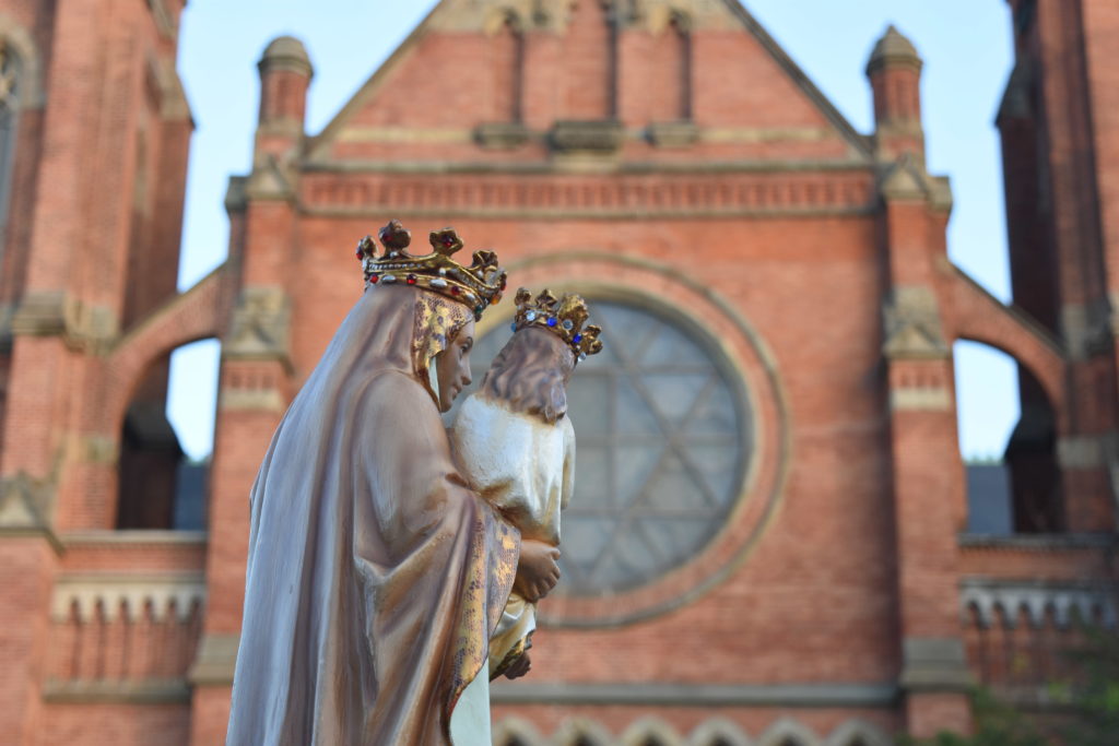 A statue of St. Anne holding the Blessed Virgin Mary is seen with historic Ste. Anne de Detroit Church in the background on July 26, St. Anne’s feast day. (Photos by Dan Meloy | The Michigan Catholic)
