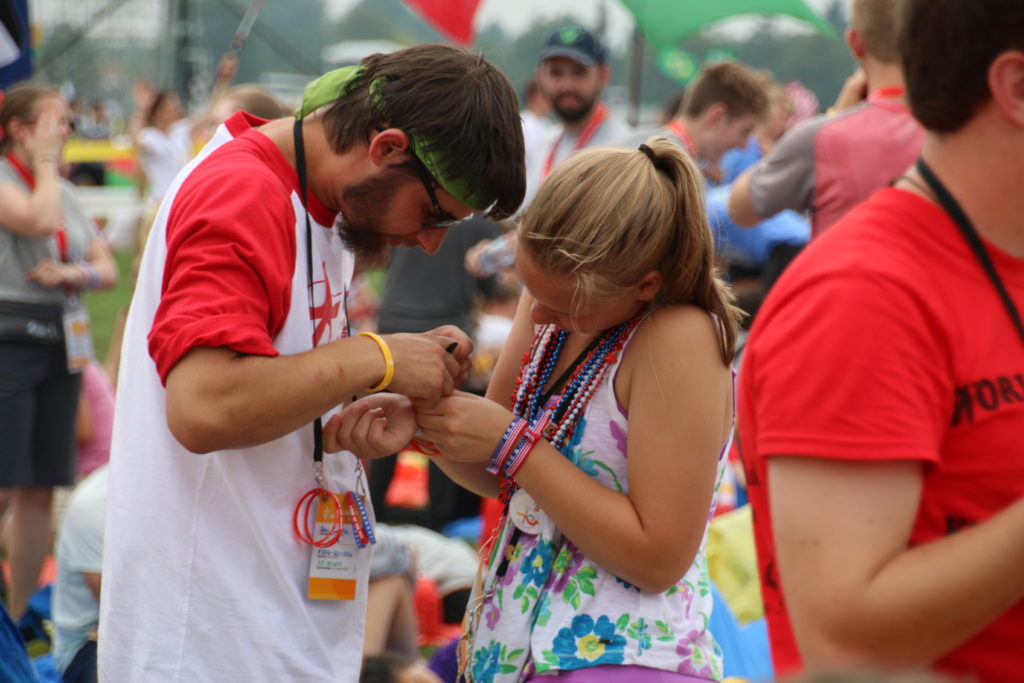 John Lakatos of St. Kateri Tekakwitha Parish in Dearborn trades keepsakes with another pilgrim at Blonia Park in Krakow, Poland, during World Youth Day. Hundreds of pilgrims from the Archdiocese of Detroit made the trip to see Pope Francis and their fellow Catholics from July 25-31. (Photos by Anne Schunior | Archdiocese of Detroit)