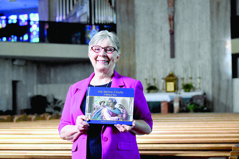 Local author and 26-year University of Detroit Mercy psychology professor Christine Panyard holds a copy of her book, “The Sistine Chapel: A Biblical Tour” inside her parish, Divine Child in Dearborn. Panyard hopes to write her next book about the experiences of local Catholics on pilgrimage to holy sites overseas.