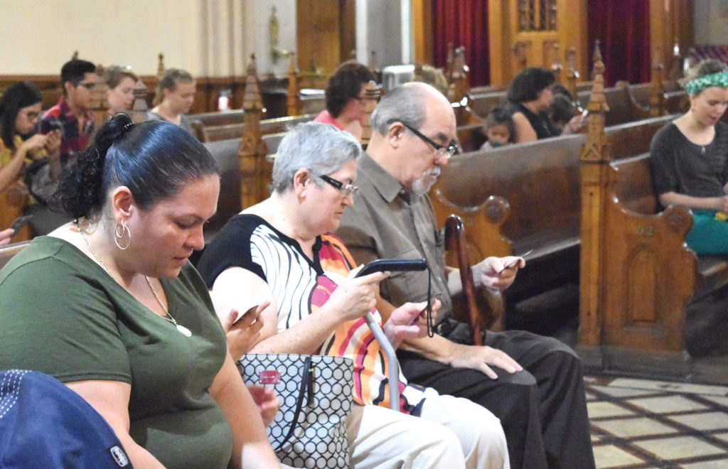 Families pray as Msgr. Charles Kosanke, pastor of Ste. Anne de Detroit Parish, leads a service Sept. 10 during the parish’s inaugural “Grandparents Day” celebration.