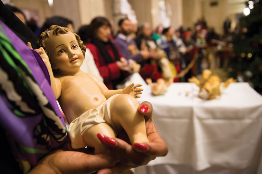 A woman holds her statue of baby Jesus in the Hall of American Saints at the Basilica of the National Shrine of the Immaculate Conception in Washington Dec. 21. People brought their figurines from home for a special blessing after after Mass fashioned after the annual tradition instituted by St. John Paul II in St. Peter's Square. (CNS photo/Tyler Orsburn)
