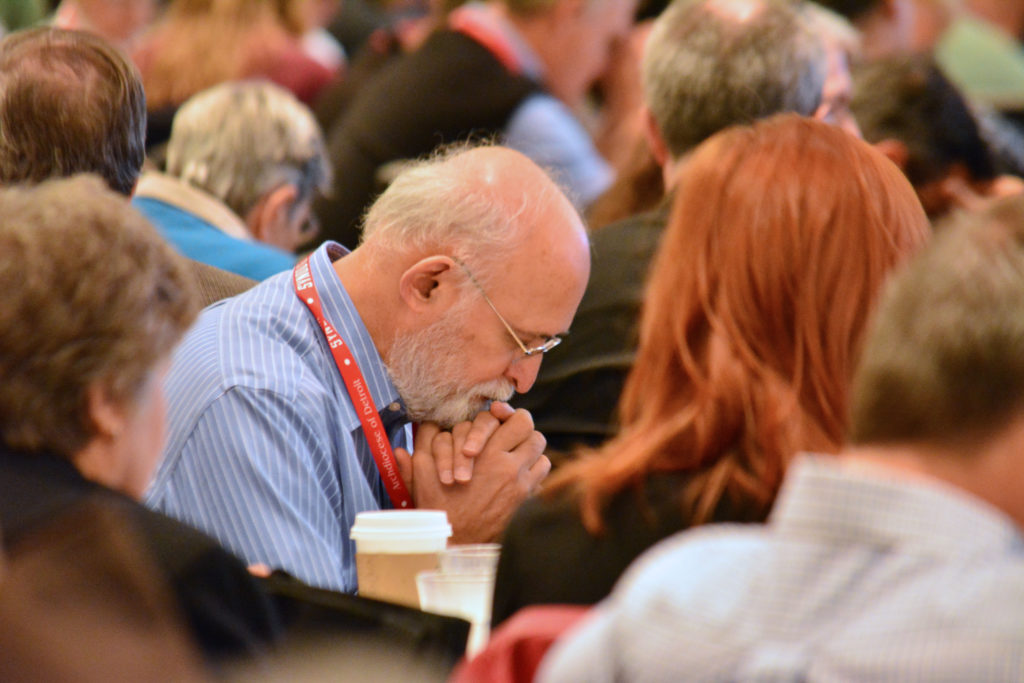 Synod members pray before the large group session on families Saturday morning during Synod 16. Of two propositions, members said the archdiocese should first “develop a plan for ongoing human and spiritual formation for all stage of life.” (Mike Stechschulte | The Michigan Catholic)